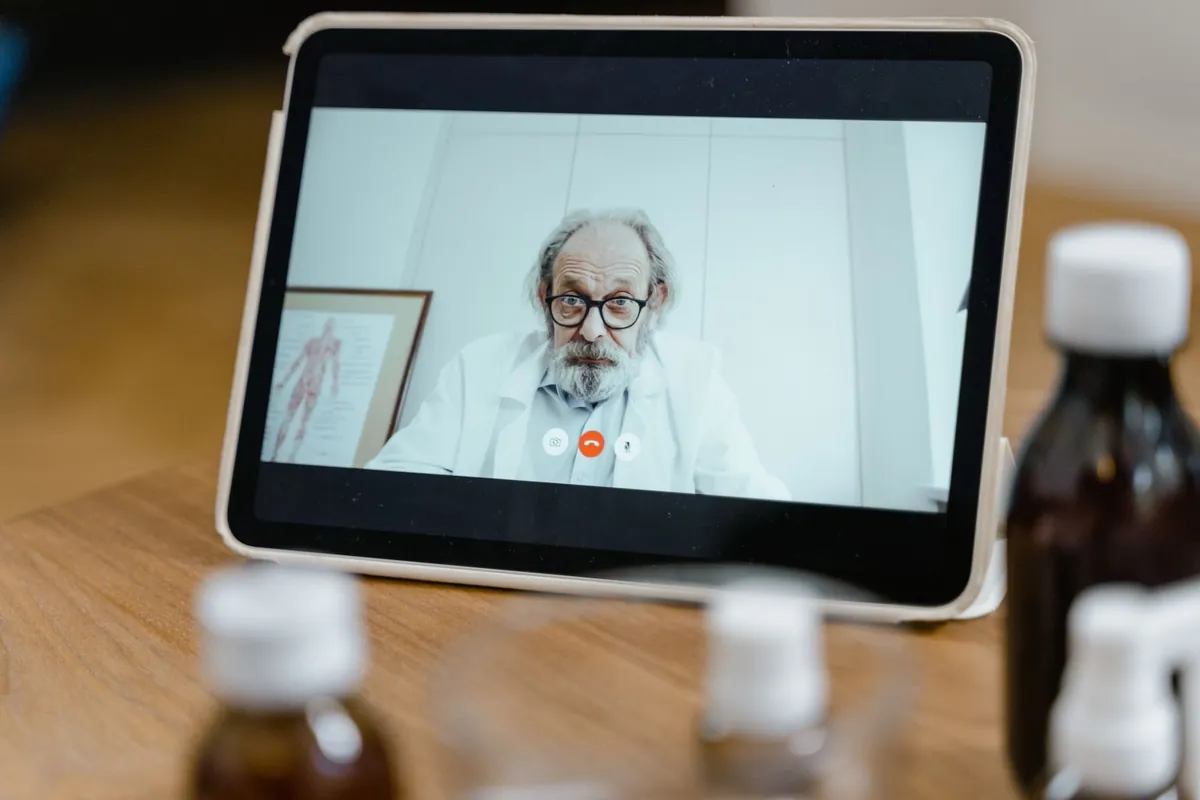 A doctor on a telehealth video call, shown on a tablet